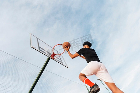 扔摄影照片_酷的运动员把篮球扔到篮筐里。高分辨率照片。酷的运动员把篮球扔到篮筐里。高品质的照片