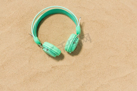 音乐、音响设备和度假概念—夏季海滩沙滩上的耳机。夏季沙滩沙滩上的耳机