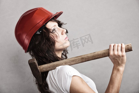 建筑工人的工具摄影照片_性别平等和女权主义。性感女孩戴着安全帽拿着锤子工具。做建筑工人的漂亮女人。