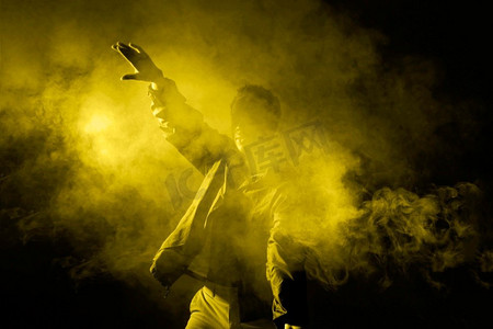 跳舞烟雾摄影照片_用照明光跳舞的人。漂亮的照片。男子舞烟照明灯