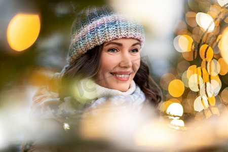 寒假和人们的概念-圣诞彩灯中幸福微笑的年轻女子肖像。圣诞彩灯中幸福年轻女子的肖像