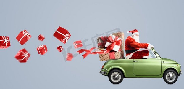 2018红色摄影照片_在汽车的圣诞老人提供圣诞节或新年礼物在灰色背景。圣诞老人在车上