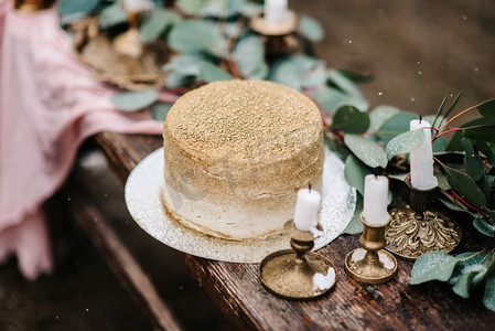 婚礼装饰，在瀑布的背景下，木凳上有一个金色的蛋糕