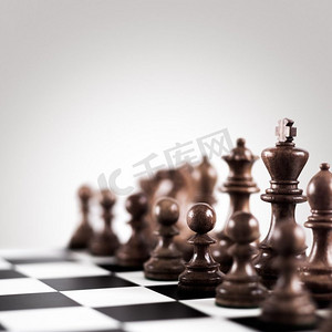 战略战术概念；棋盘上的黑色木质棋子排成一排，准备下棋。