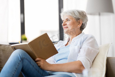 年龄，休闲和人的概念—快乐的高级妇女写笔记本或日记在家里。老年妇女写笔记本或日记在家里