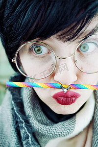 彩活动摄影照片_戴着彩虹吸管的年轻有趣的女人