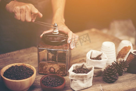 咖啡机和咖啡豆摄影照片_木质背景的复古咖啡机和咖啡豆