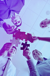 一群商务人士组装拼图游戏，代表团队支持和帮助的概念
