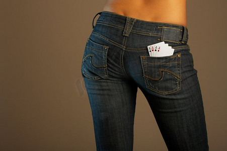 女孩的底部在牛仔裤与四张卡在口袋里。牛仔裤想象力（运气）
