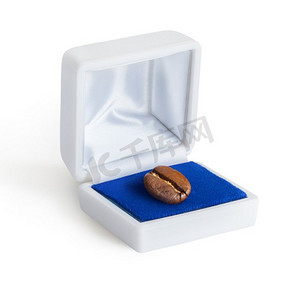 首饰盒的创意概念照片，白色背景上有一颗咖啡豆。
