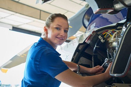 女航空工程师在机库直升机上工作的肖像
