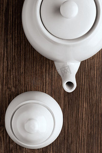 木桌上的白色中国茶壶和糖碗的形象。