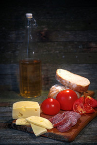 香肠、西红柿、奶酪面包放在木头的背景上。香肠番茄奶酪面包