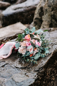 牡丹结婚花束，石头上系着彩带，特写，S在下雪