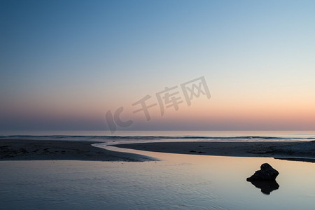 多彩活力摄影照片_美丽的多彩充满活力的日出在低潮海滩景观。令人惊叹的丰富多彩充满活力的日出在低潮海滩景观和平的场景