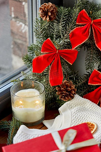 冬季窗户摄影照片_ 花环、蜡烛、毛衣、窗户