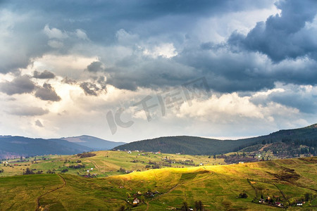 同担风雨共抗疫摄影照片_绿意盎然的春天高山景色。山坡上的山村。春风雨雨的天气