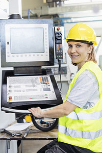 女工在工厂控制面板操作机械的肖像