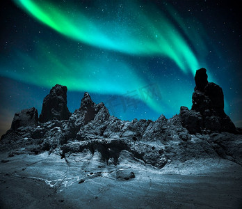 在群山和平原上的北极光，在夜晚的星光下。北极光