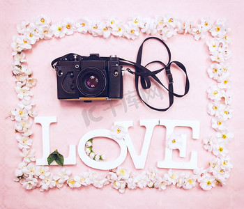 Love Word和一个粉色背景下带有花卉边框的模拟摄像头