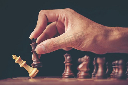 一个商人的老式风格形象与紧握的手计划战略与象棋数字在一张老木桌上。