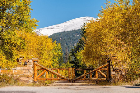 秋天阳光明媚的一天，美国科罗拉多州未铺设的道路上，用原木做成的乡村大门。