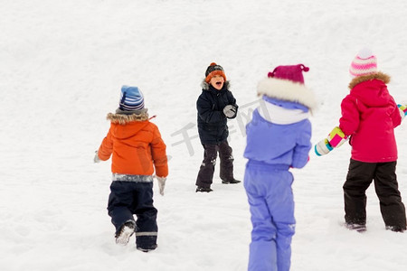 童年，休闲和季节概念—一群穿着冬装的快乐的小孩子在户外玩耍。快乐的小孩子在冬天户外玩耍