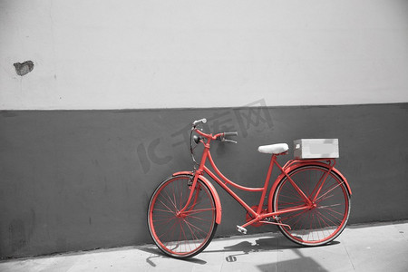 红色自行车在白色墙壁背景。黑白照片