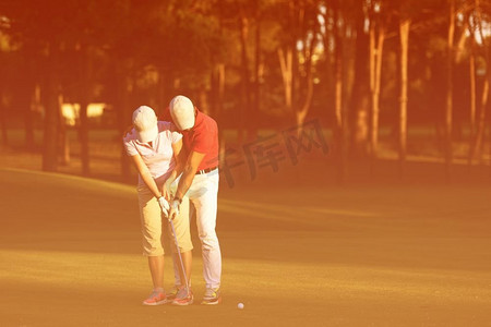 活动说明摄影照片_男高尔夫教练教女高尔夫球手，私人教练在高尔夫球场授课。高尔夫球说明