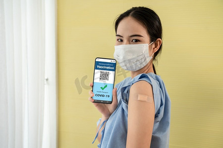 app展示摄影照片_年轻的亚洲妇女在手机上展示疫苗护照，以验证数字文件的旅行许可。疫苗护照V2