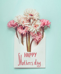 母亲节快乐！贺卡，信封上有漂亮的花束，背景为淡蓝色桌面，俯视，复印空间，平铺