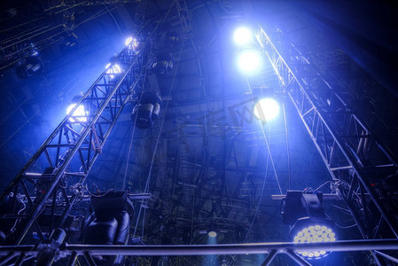 装饰性能摄影照片_音乐会前的舞台上闪耀着探照灯的光束。前一阶段