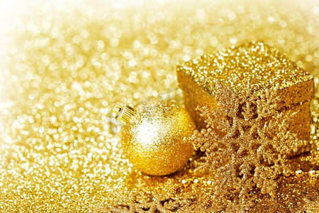 雪花框摄影照片_闪亮的金色圣诞装饰在闪光背景