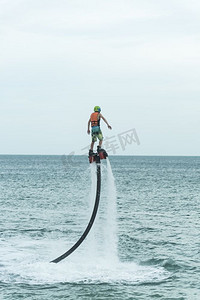 泰国海滩—普吉岛—2016年9月30日：一个身份不明的家伙正在玩一个新的水上运动称为飞板在海湾在普吉岛，泰国