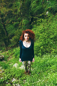 年轻女子失去了在绿色森林 