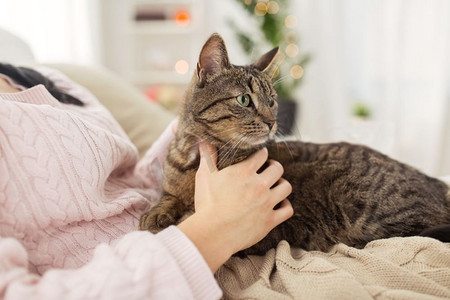 宠物、卫生与人的概念--女主人在家中与猫猫在床上的特写。主人与猫猫在家中床上的特写