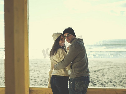一对情侣在海滩酒吧聊天和玩耍。幸福的情侣在秋日的海滩上共度时光彩色滤镜