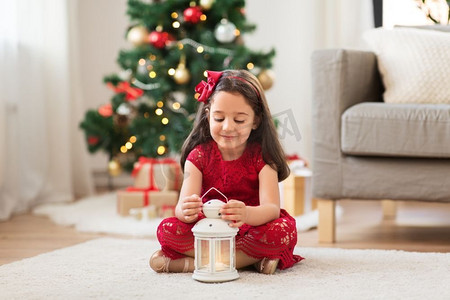 圣诞节，假日和童年的概念—小女孩与灯笼在家里。小女孩与灯笼在家里圣诞节