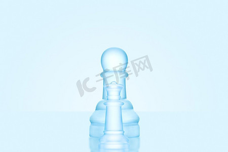 象棋游戏摄影照片_象棋游戏的概念是一个冰冷的磨砂棋子独自站在冰川棋盘上。