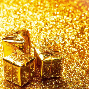 金金色卡摄影照片_装饰金盒与节日礼物在闪亮的闪光背景