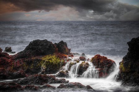 海洋中的风暴。水中的石头是在长时间曝光后拍摄的。海洋中的风暴。