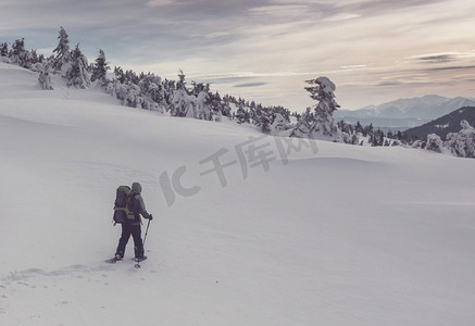 登山徒步的人摄影照片_冬季远足。冬季山区的徒步旅行者