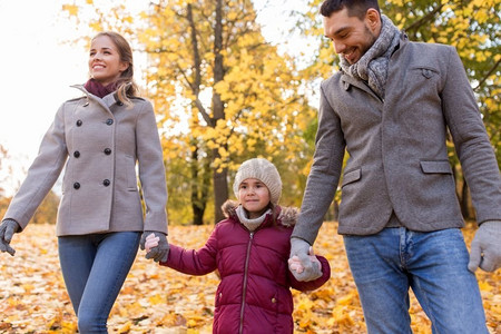 家庭，季节和人的概念—快乐的母亲，父亲和小女儿在秋天公园散步。在秋天公园散步的快乐家庭