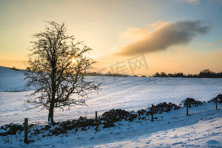 日出时分，美丽的白雪覆盖着山顶的冬景。风景画。英国山顶地区日出时分白雪覆盖的冬季景观
