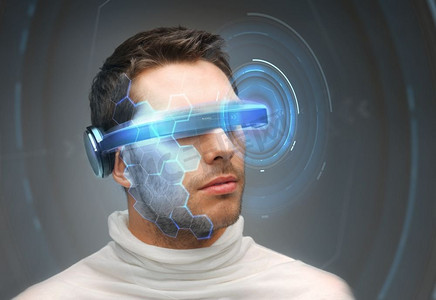 灰色科技摄影照片_未来技术和人概念-人在3d眼镜与虚拟全息图在灰色背景。男子在3D眼镜与虚拟全息图