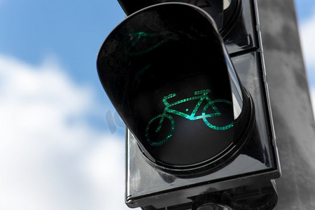 道路和信号概念-蓝天上自行车的绿色交通灯特写。蓝天之上的自行车绿灯