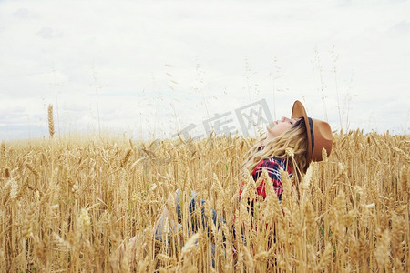 夏日，一位年轻的金发乡下妇女在麦田里穿梭