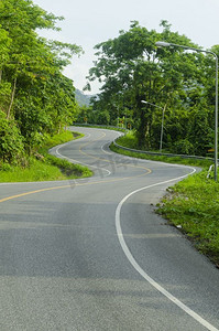 高速公路领域摄影照片_柏油路急弯沿着热带森林蜿蜒前行。