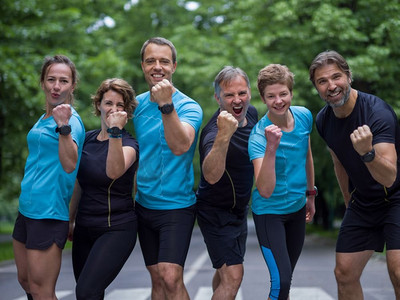 一组健康的人在城市公园慢跑的肖像，跑步者团队晨练。晨训时跑步队的肖像
