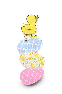创意复活节概念照片，白色背景上有一只鸭子和纸做的鸡蛋。